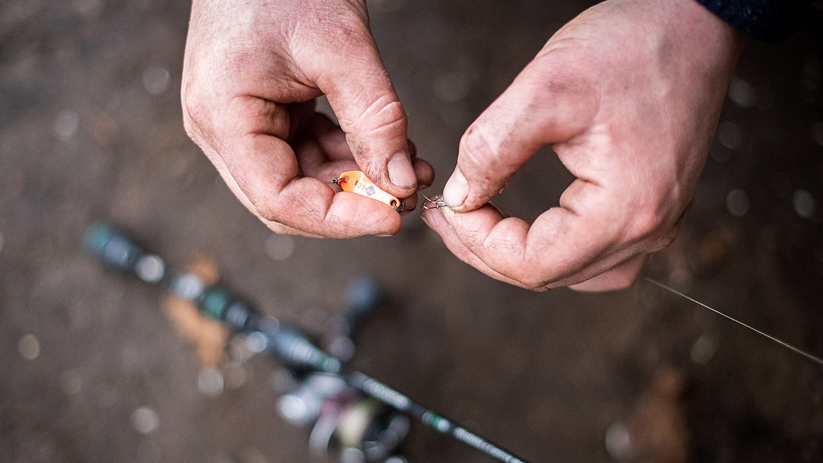 Man attaching bait to a fishing pole