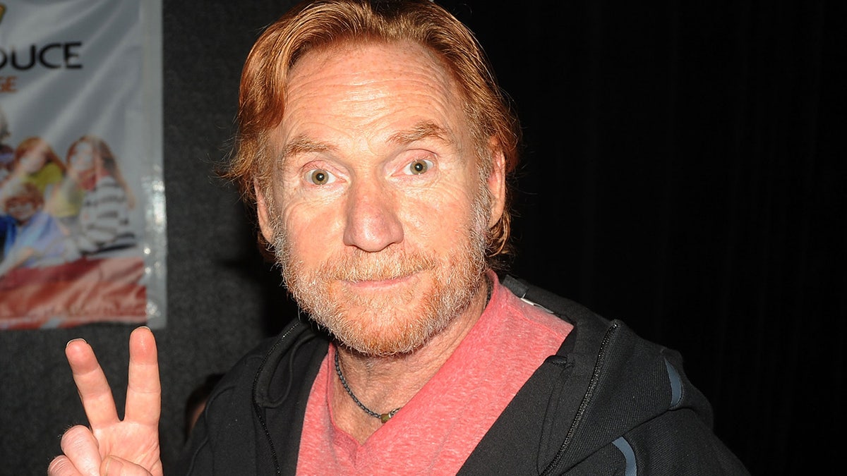 Danny Bonaduce flashes a peace sign at theater panel