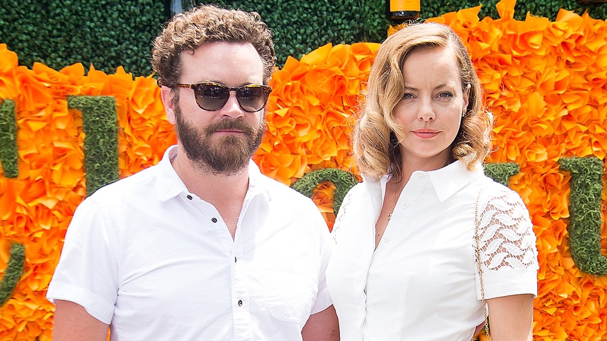 Danny Masterson and Bijou Phillips in front of flowers