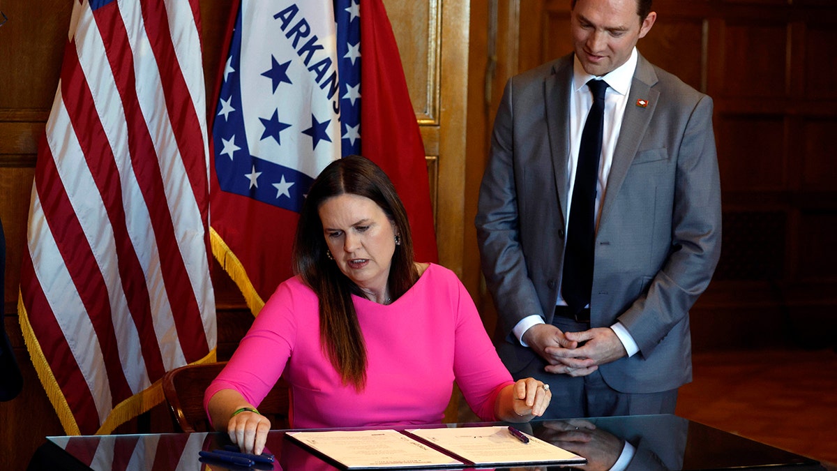 Arkansas Governor Sarah Huckabee Sanders signing a bill