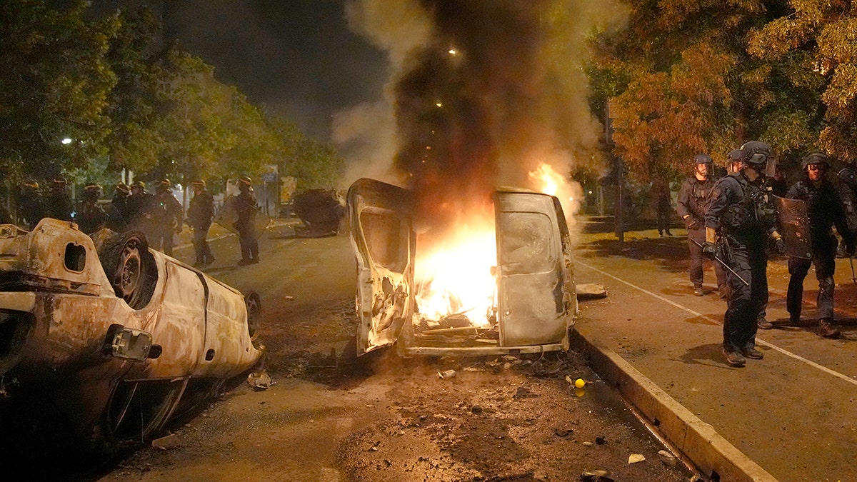 A vehicle is consumed by flame during riots in Nanterre, outside of Paris
