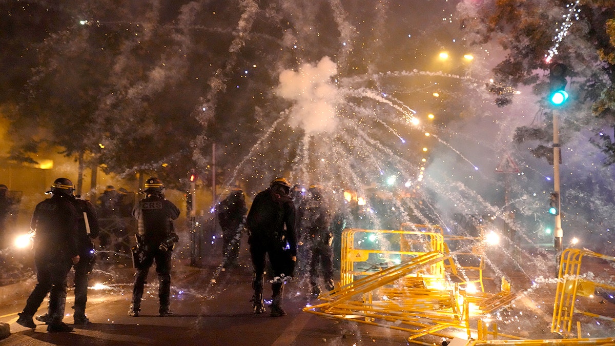French police fire tear gas back at protesters who are launching fireworks at them in Nanterre, outside of Paris