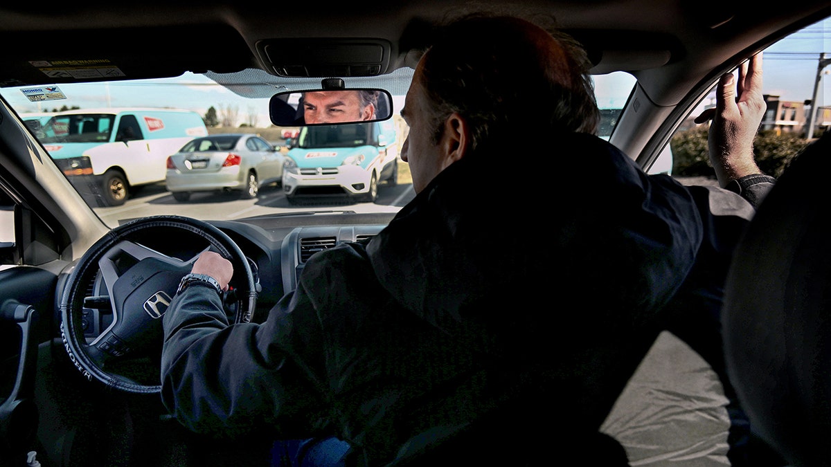 Former postal worker Gerald Groff demonstrates how postal service workers drive their trucks