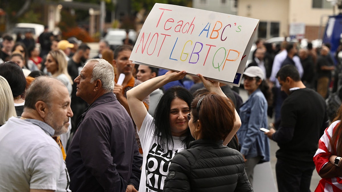 A protester holds a sign that reads, "teach ABC's not LGBTQP"