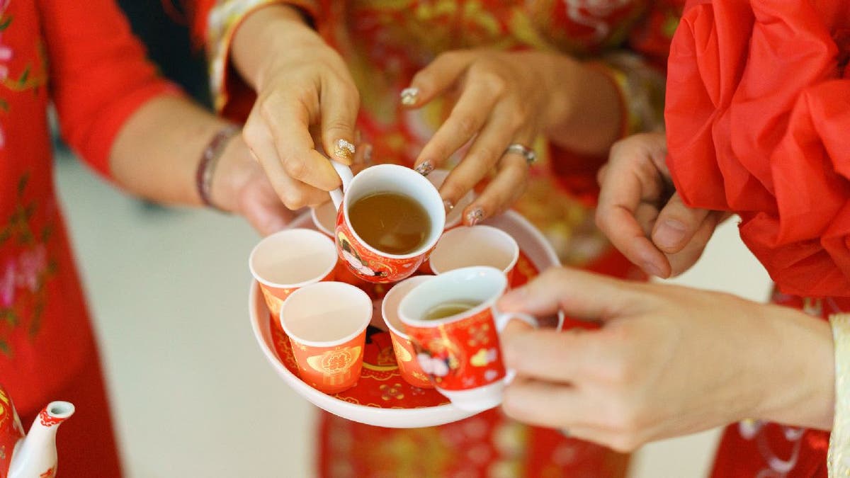 A newlywed serves tea during a traditional Chinese tea ceremony.