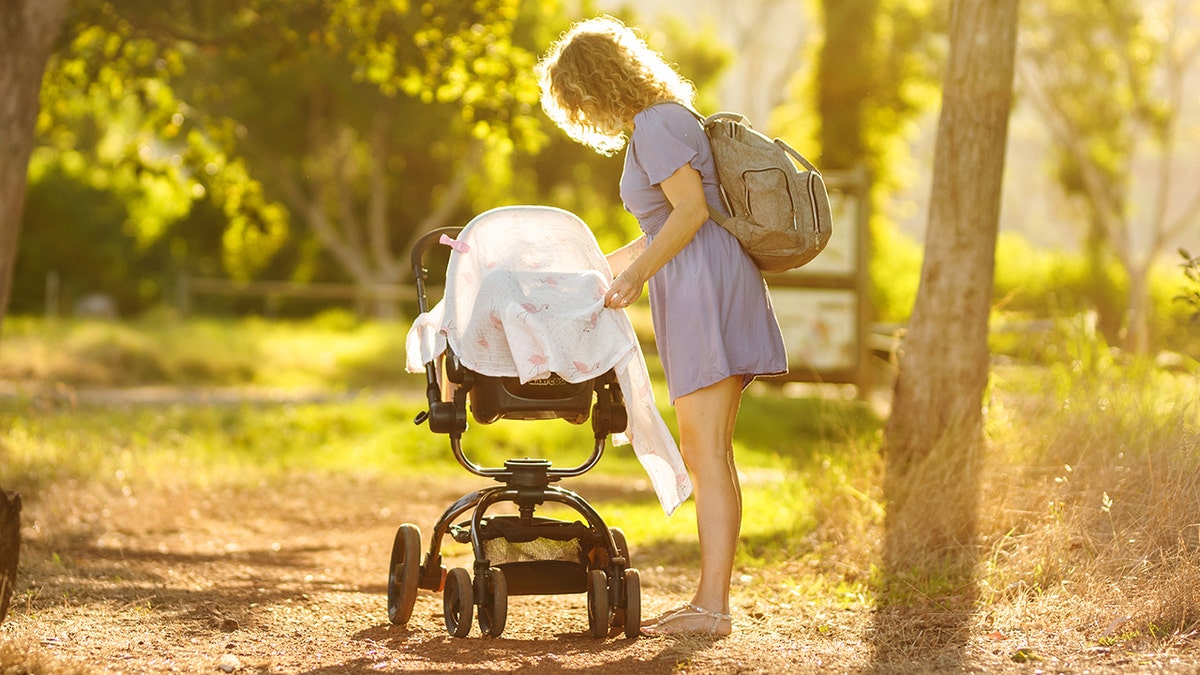 draped stroller with mom attending baby
