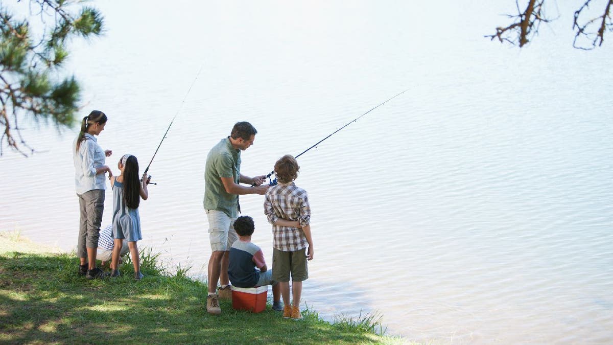 Family of five goes fishing by lakeside