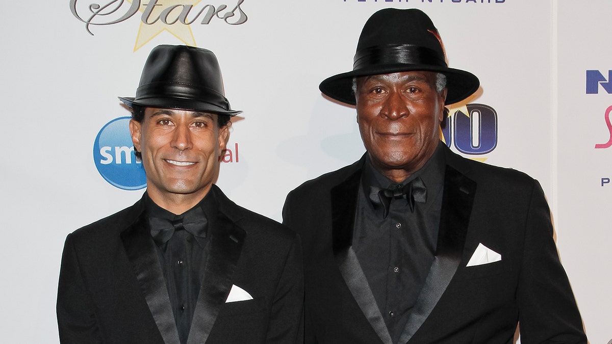 John Amos matches son KC with black leather fedora and snazzy black suits