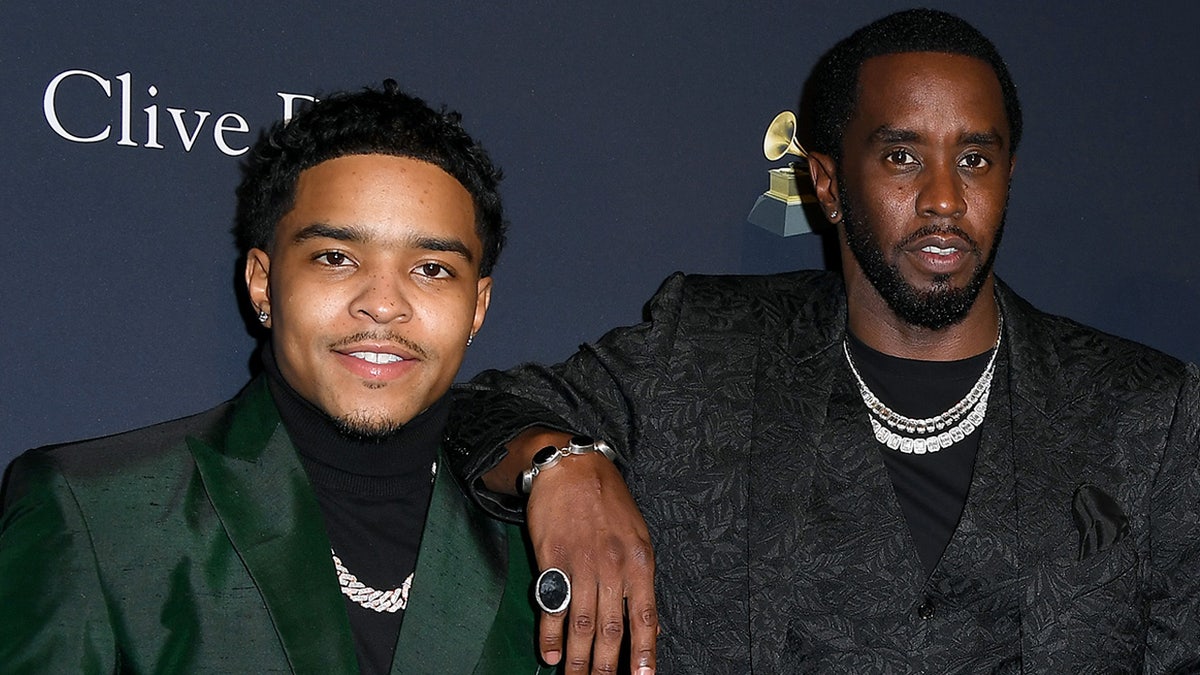 Sean Combs wears black paisley print suit with son Justin Combs in green blazer at event