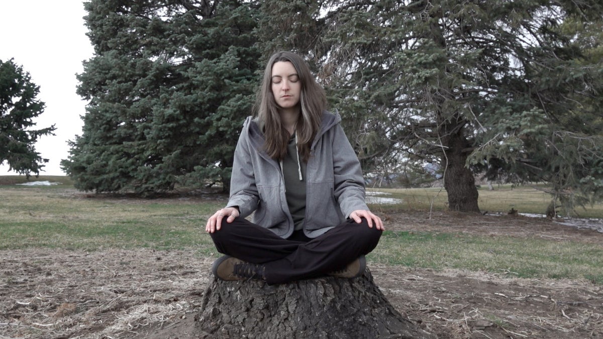 Psychedelic Club president meditates on a stump