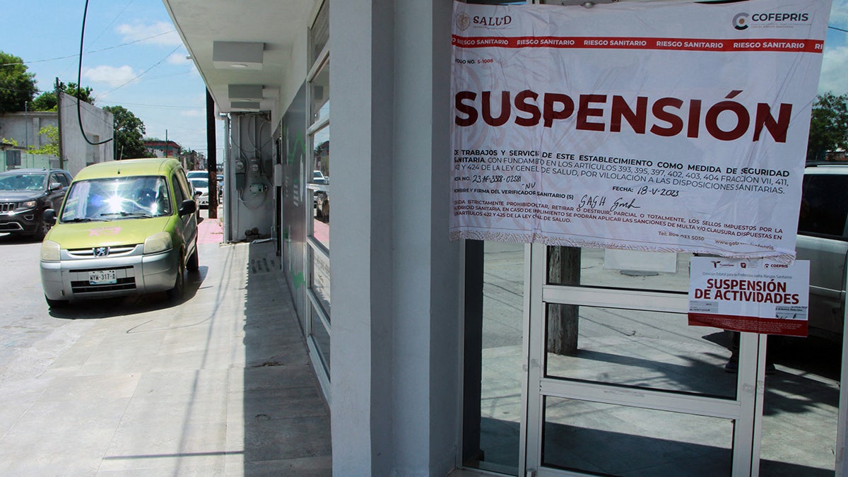 A sign outside a health clinic in Matamoros, Mexico, reads "suspended"
