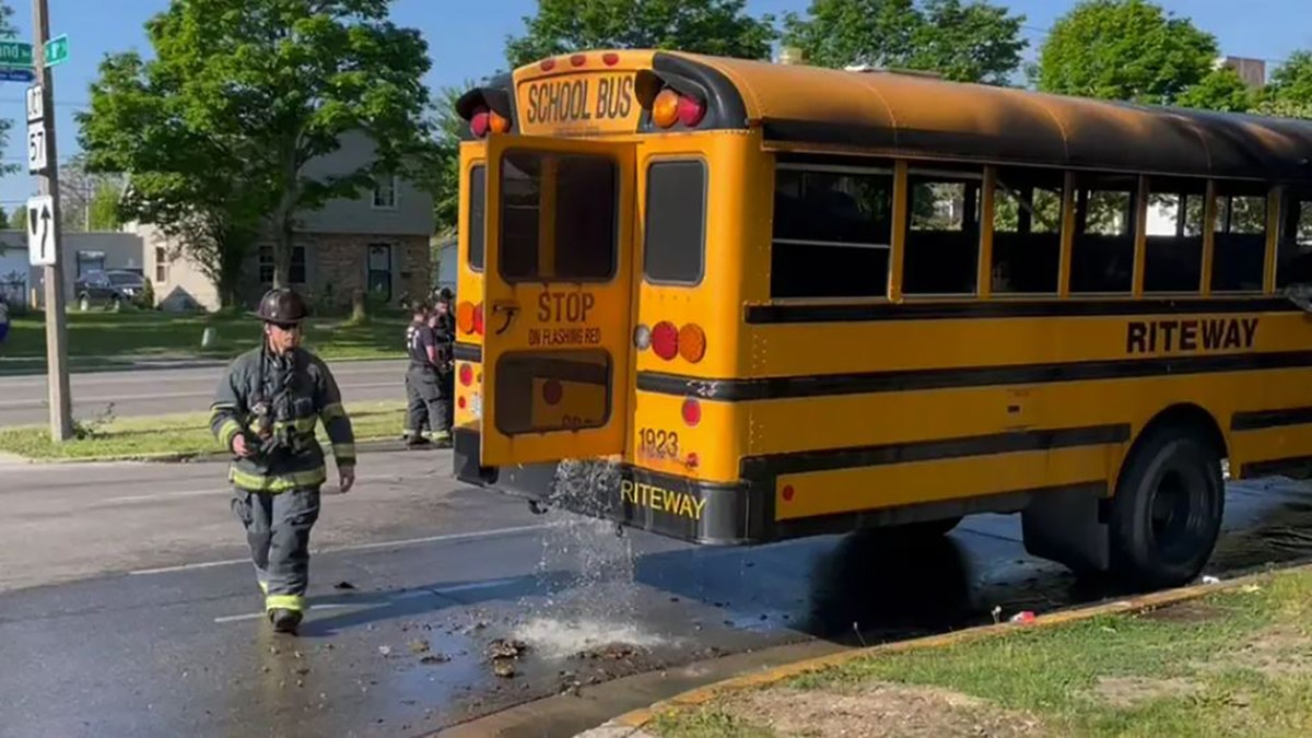 Firefighters dousing bus that was on fire