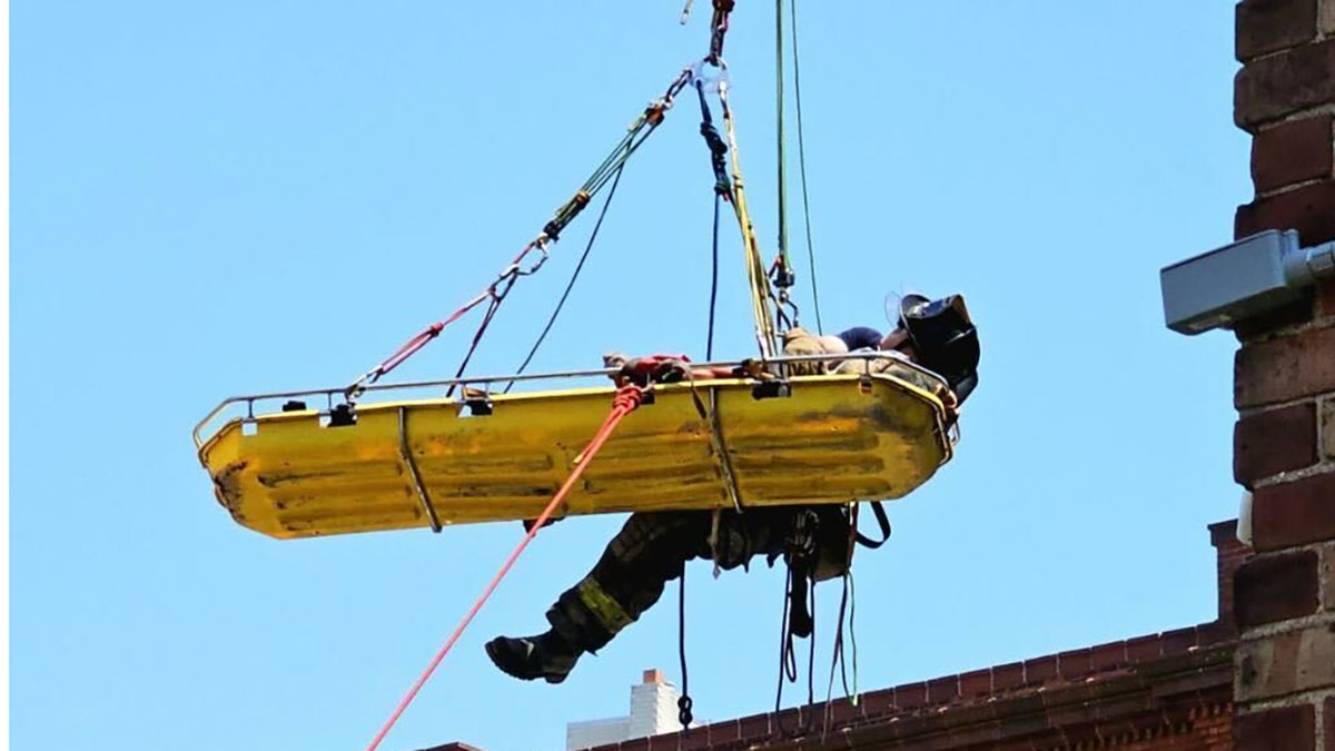 Person being airlifted from building on stretcher