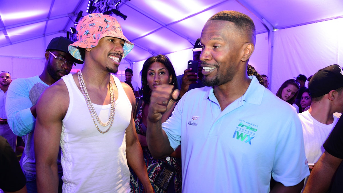 Nick Cannon laughing with Jamie Foxx