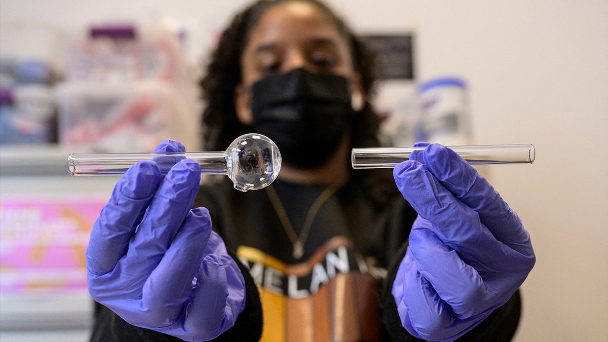 Harm reduction staff member holds a glass pipe
