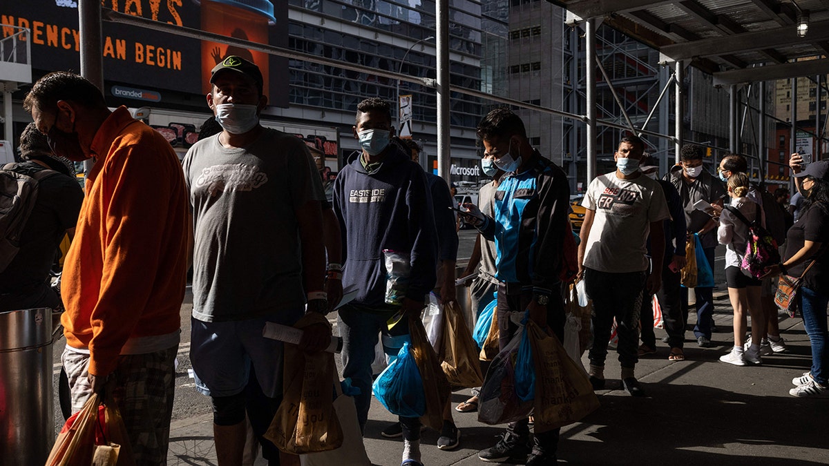 migrants wait in line