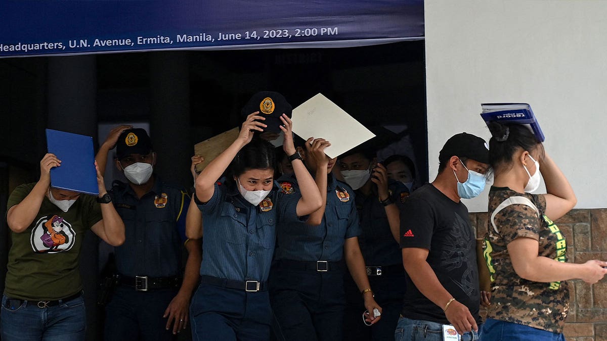 People evacuate a police headquarters building in Manila on June 15, 2023, after a 6.2 magnitude earthquake struck the Philippines.