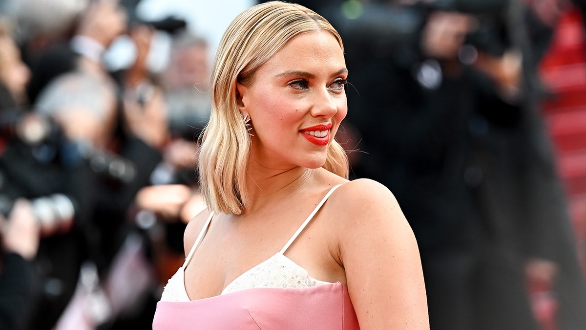 Scarlett Johansson walks red carpet at Cannes wearing pink dress with white bra straps showing