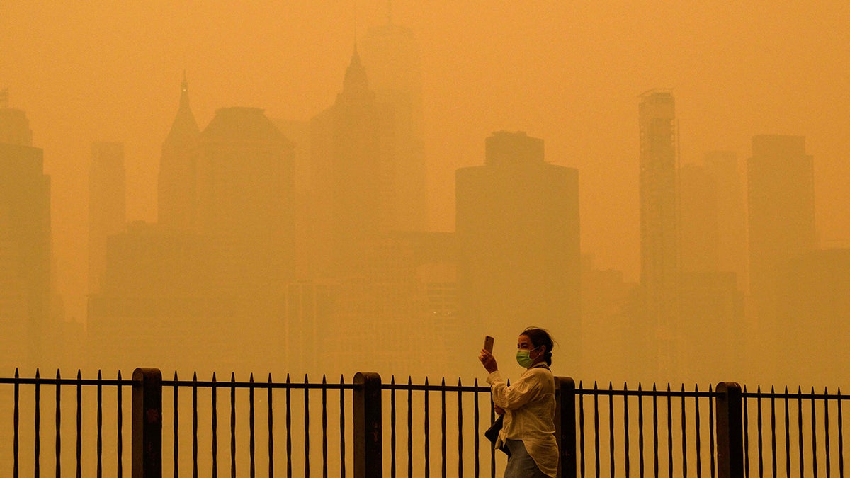 woman taking picture of New York sky