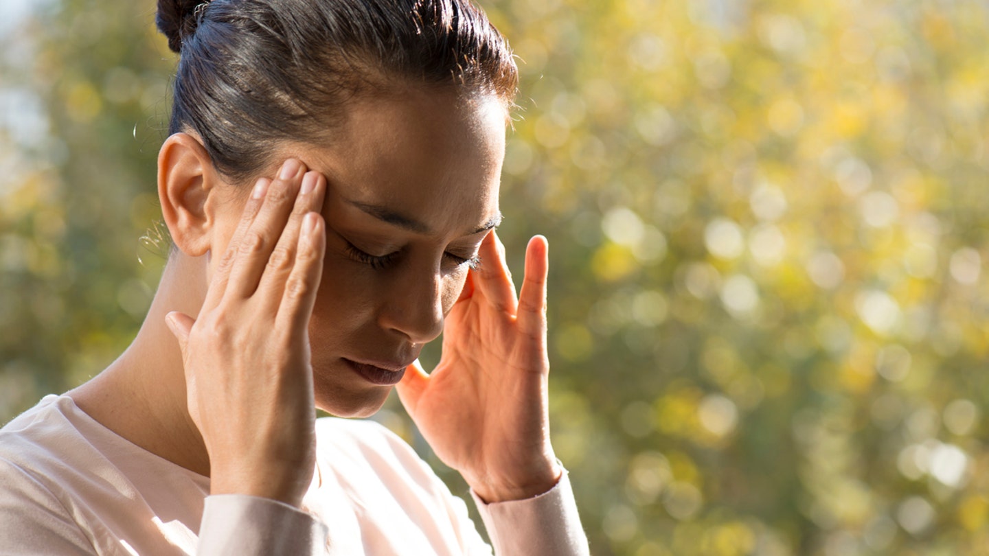 woman with headache outside