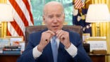 President Joe Biden sitting at desk in oval office