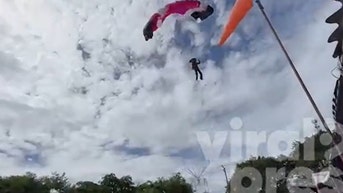 Out-of-control paraglider barrels into shop roof as shocked onlookers watch: video