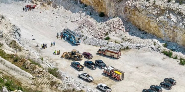 aerial view of car in quarry and emergency vehicles nearby