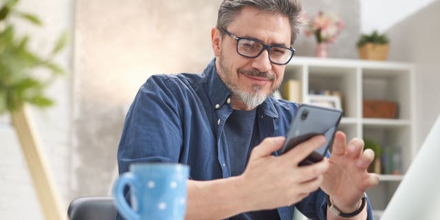 Man smiles at his smartphone