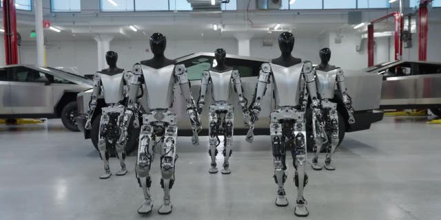 Photo of Tesla robots in front of a Cybertruck.