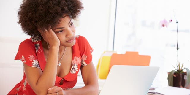 Sad woman stares at her laptop