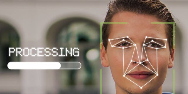 Photo of a person with their face being mapped out by facial recognition software.