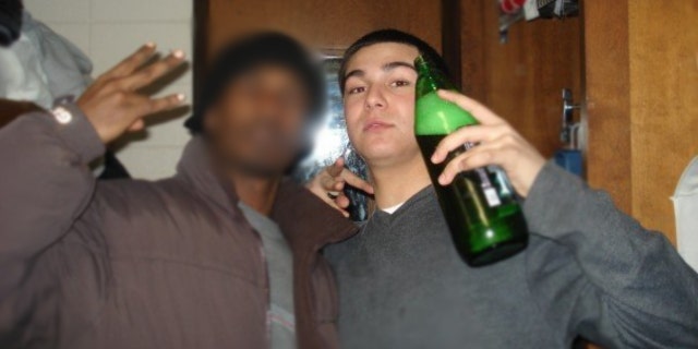 Nilo poses with a afriend while holding a green bottle