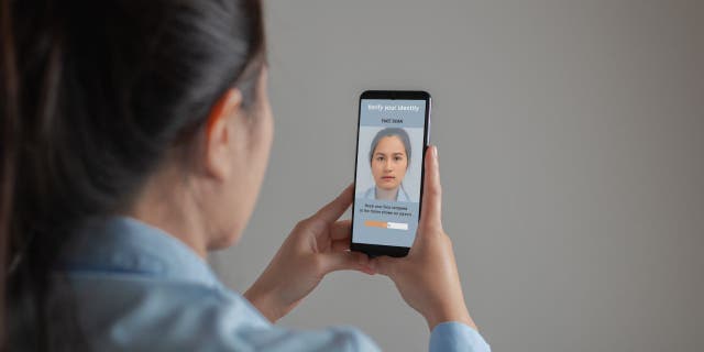 Photo of a woman holding up her phone.