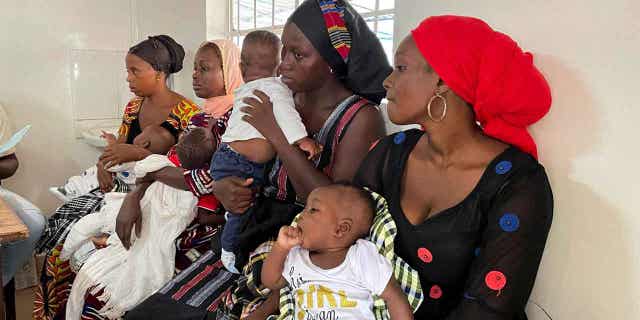 Mothers wait with their children