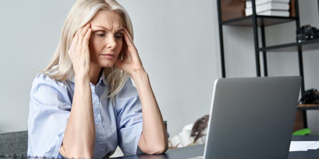 A picture of a woman stressed on her laptop