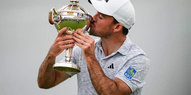 Nick Taylor kisses the trophy