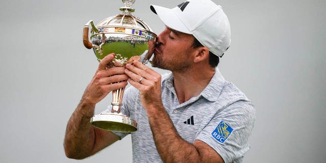 Nick Taylor kisses the trophy