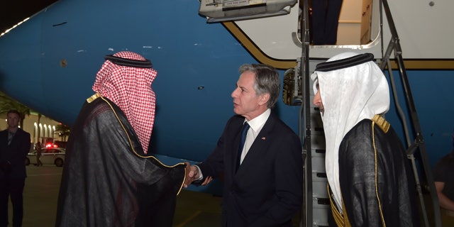 Blinken shakes hand of Saudi official