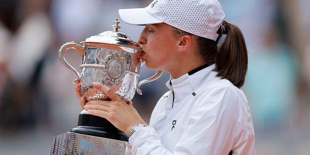 Poland's Iga Swiatek kisses the trophy