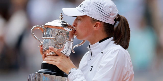 Poland's Iga Swiatek kisses the trophy