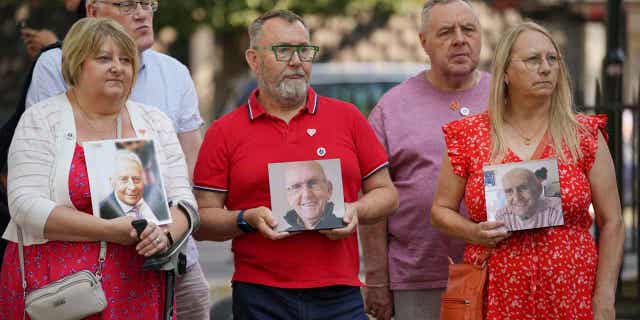 People hold pictures of loved ones