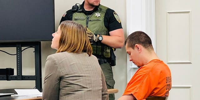 Idaho murder suspect Majorjon Kaylor wearing orange inmate jumpsuit and looking down in court