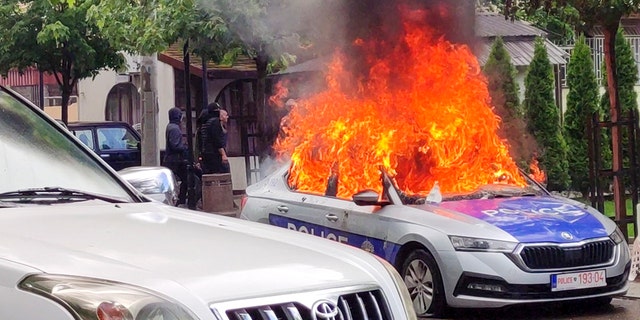 Coche de policía en llamas en Kosovo