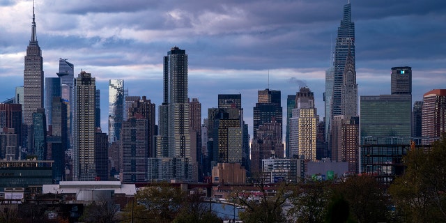 The sun sets behind the New York skyline