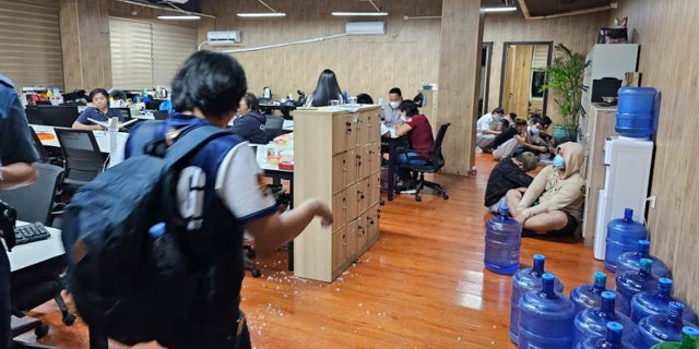 La policía filipina ha rescatado a más de 2.700 trabajadores de una supuesta redada cibernética en un edificio 4 Un oficial de policía camina a través de una oficina de allanamiento