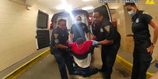 Richard Cox being carried by officers