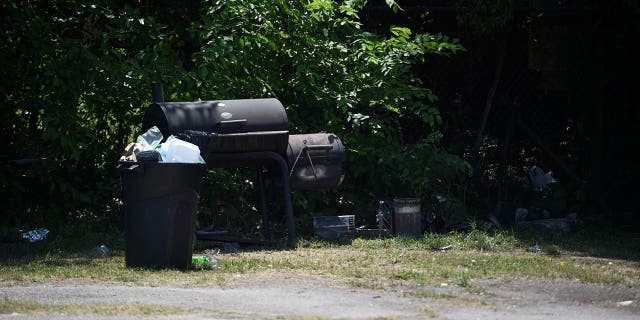 Trash and BBQ outside the Outcast motorcycle gang clubhouse