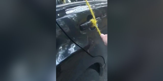 A yellow rope is tied to the car door handle