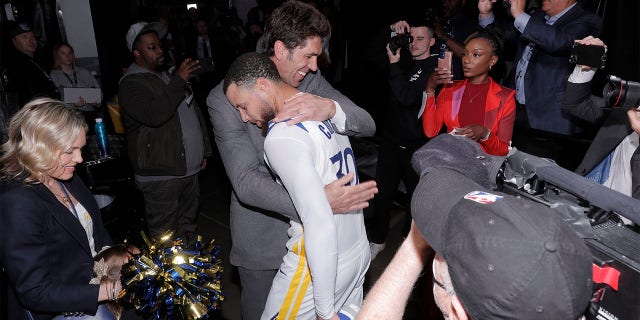 Bob Myers hugs Steph Curry