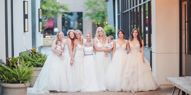 Seven women wearing white dresses.